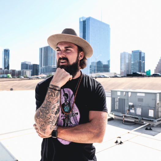 Man looking pensive on top of austin rooftop